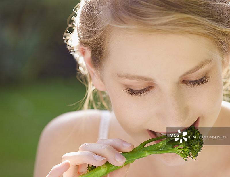 年轻女性近距离吃西兰花图片素材