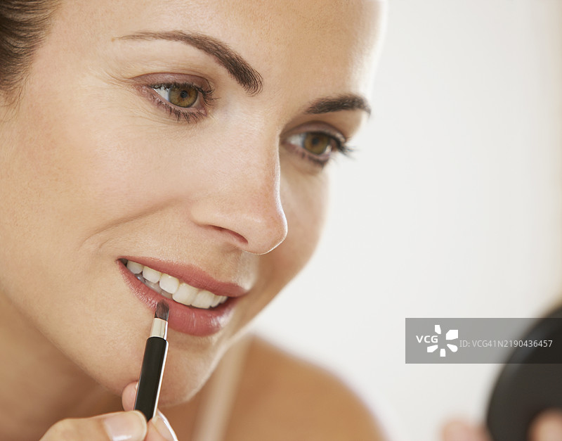 女性使用唇膏刷，特写视图图片素材