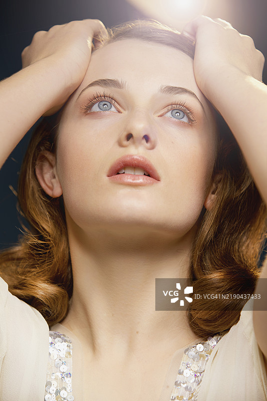 年轻女性双手托头仰望天空图片素材