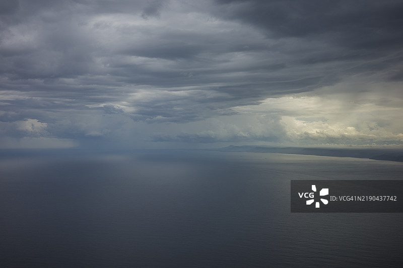 海上阴暗的戏剧性乌云天空，自然照片背景。黑暗的暴风云背景。图片素材
