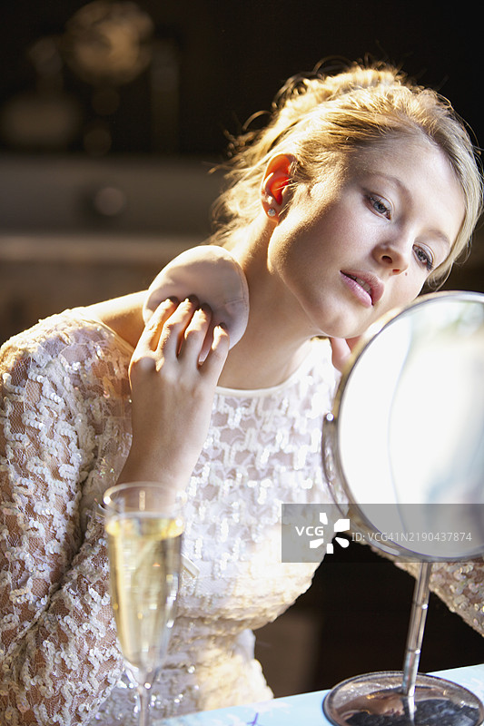 年轻女性在脖子上涂抹粉末图片素材