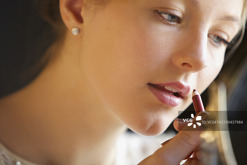 年轻女性使用唇线笔的特写镜头图片素材