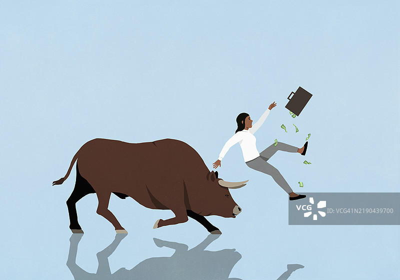 公牛用角撞击手持钱箱的女商人投资者图片素材