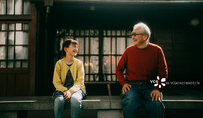 祖父和孙女在房子前交谈图片素材
