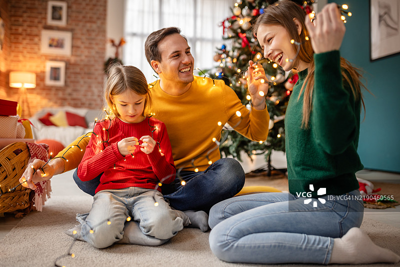 快乐的家庭在家一起装饰圣诞节图片素材