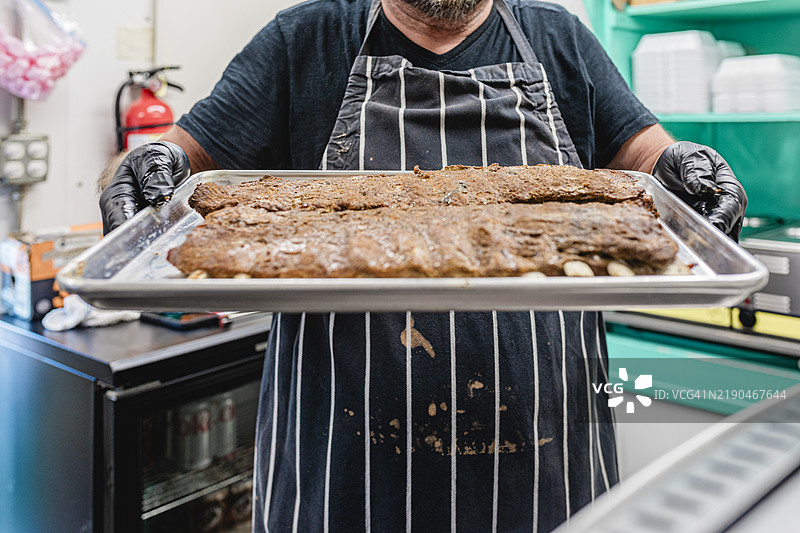 厨师展示一盘烧烤肋排图片素材