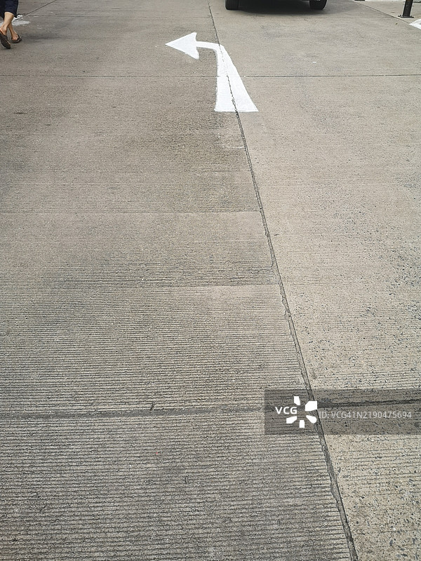混凝土道路上的白色左转箭头图片素材