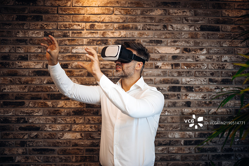 商人在现代办公室中使用虚拟现实头盔探索虚拟现实图片素材