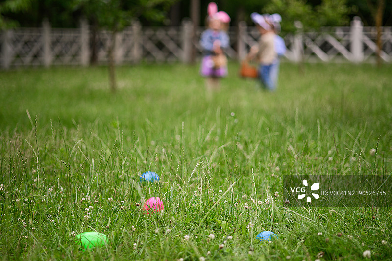 五彩缤纷的复活节彩蛋藏在草丛中，等待户外寻蛋活动的发现图片素材