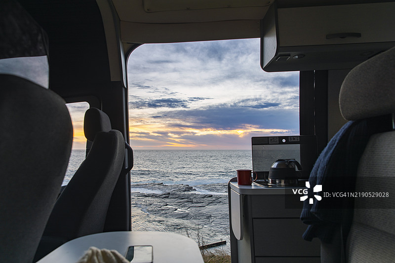 冬日清晨，苏格兰东海岸停靠的房车侧面景观，阳光开始升起。图片素材