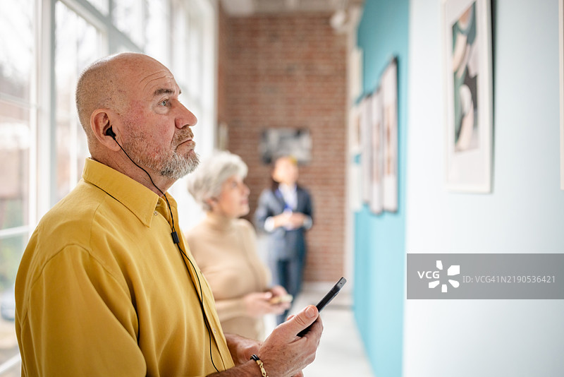 参观者在艺术画廊展览中探索，策展人提供协助图片素材