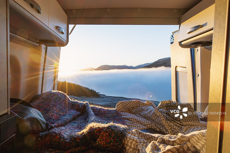 在苏格兰高地洛赫洛因附近停靠的露营车后方欣赏到的美丽日落景色图片素材