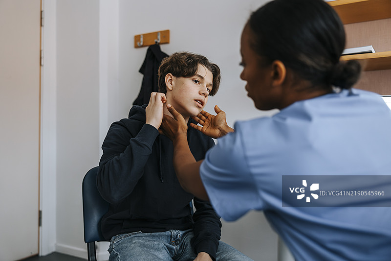 女医生在医疗检查室里为患者检查颈部。图片素材