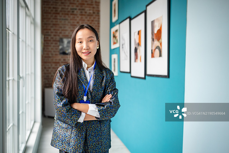 艺术画廊策展人在框架艺术作品展示前自信地站着图片素材