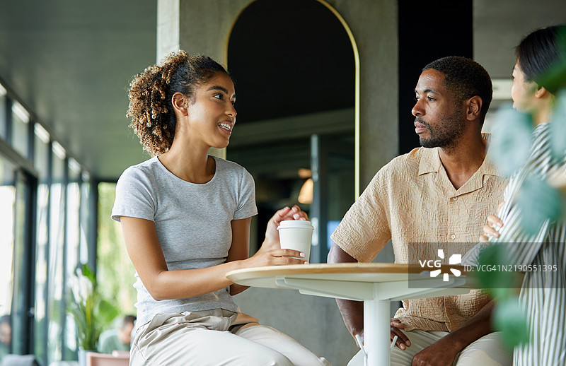 年轻女性与同事在会议中讨论图片素材
