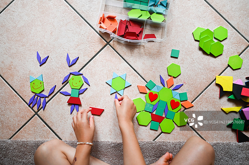 小女孩在玩七巧板拼图。图片素材