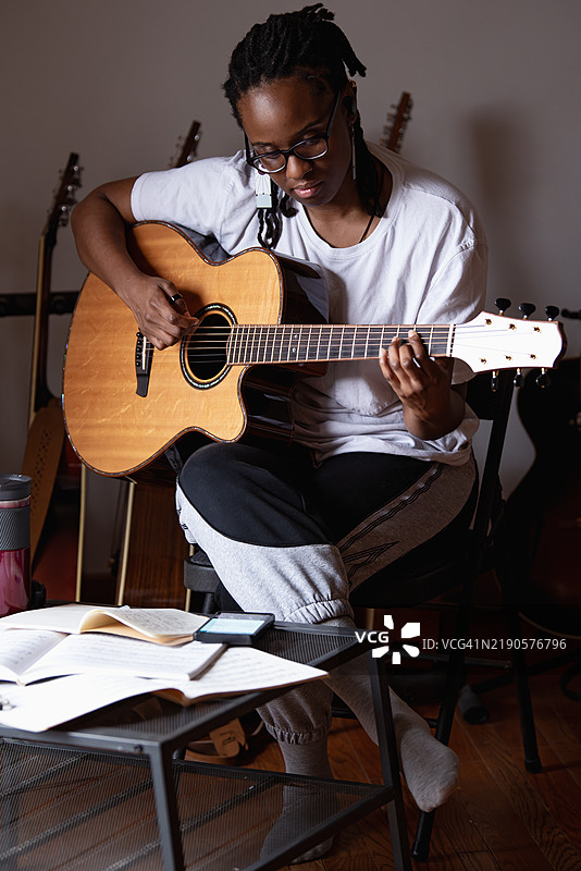 女人站在吉他架后面图片素材