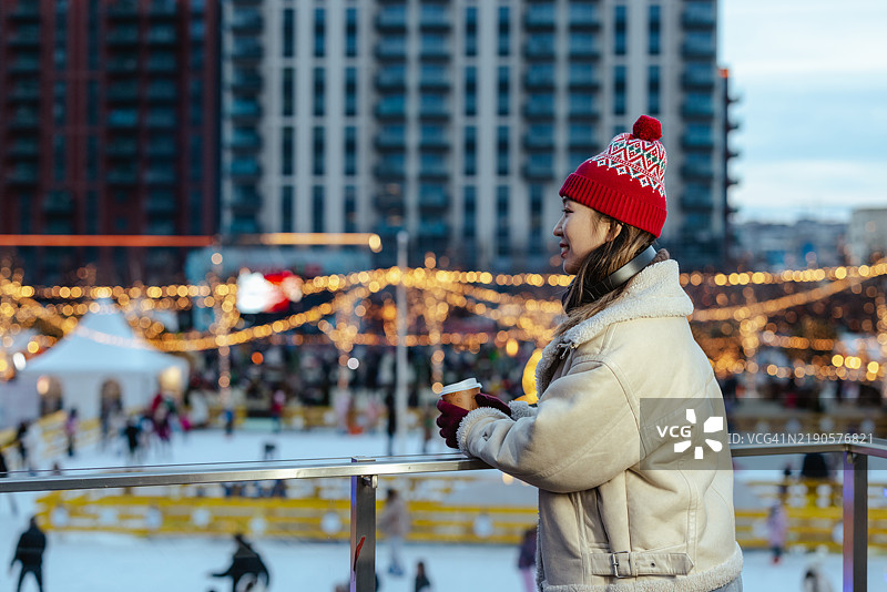 女人在户外滑冰场享受冬季的夜晚图片素材