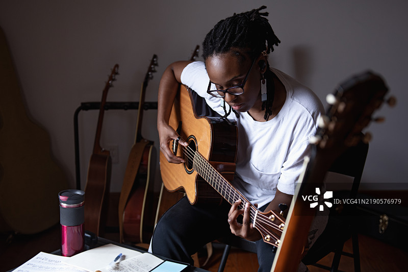 女人站在吉他架后面图片素材