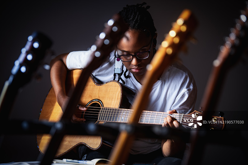 女人站在吉他架后面图片素材