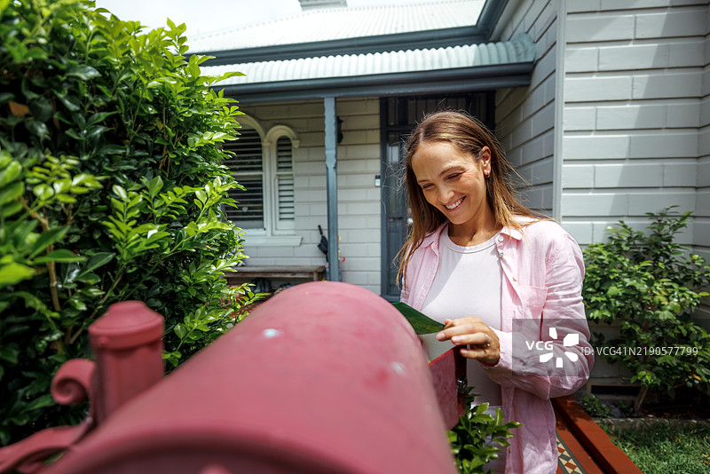 穿着休闲的快乐女性正在收邮件图片素材