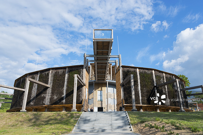 圆形木质和金属建筑，配有楼梯，背景是蓝天和绿色的风景，盐水，毕业塔，米沃姆林温泉小镇，米沃姆林，利贝穆尔，瓦尔米亚-马祖里，波兰，欧洲图片素材