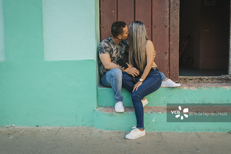 年轻情侣在古巴卡马圭的台阶上亲吻图片素材