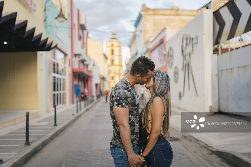 古巴卡马圭街头年轻游客亲吻的场景图片素材