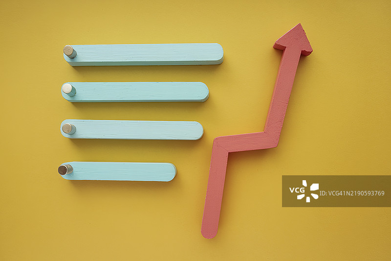 在黄色背景上色彩斑斓的箭头和条形，代表增长、进步和数据可视化图片素材