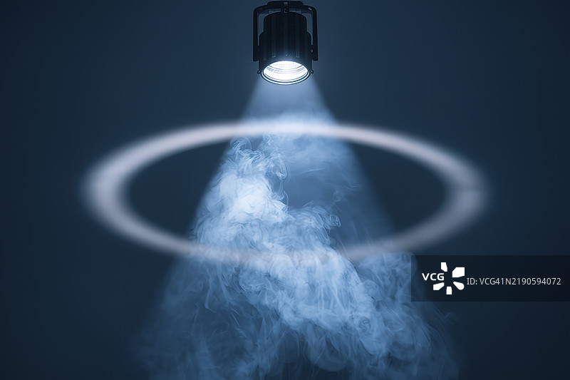 一束聚光灯照射在烟雾弥漫的氛围中图片素材