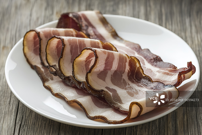 一盘白色盘子上的生培根图片素材