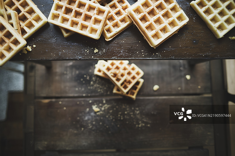深色木质背景上的华夫饼，条纹华夫饼，桌子上的华夫饼和碎屑，俯视图图片素材