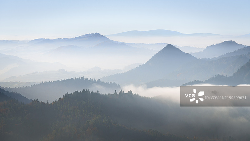 雾气弥漫的山丘层层叠叠，渐渐消失在地平线上图片素材