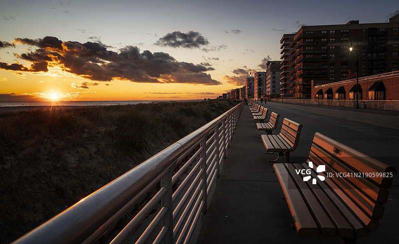 日落时分，空荡荡的长椅映衬着天空，纽约州长滩，美国图片素材