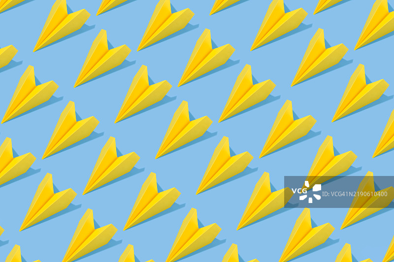 蓝色背景上的重复黄色纸飞机图片素材