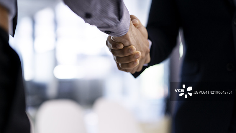 商业环境中专业握手的特写，象征着协议或成功图片素材