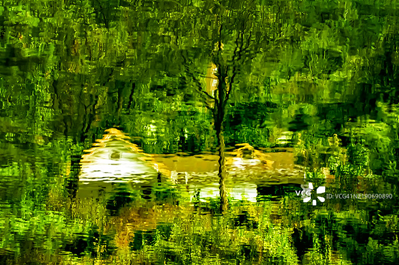 宁静的倒影：水中的房屋和树木图片素材