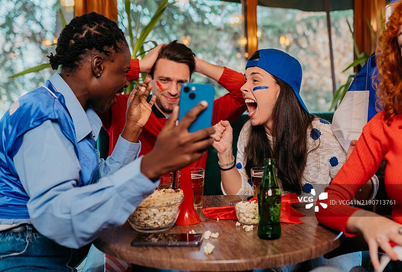 朋友们在看电视时讨论足球图片素材