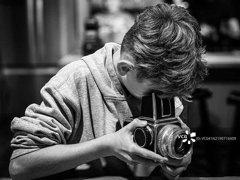 年轻男子/青少年用复古相机拍照图片素材
