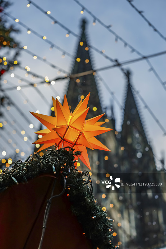 科隆大教堂的圣诞市场,闪耀的黄色星星装饰在圣诞摊位上,背景是科隆大教堂,位于德国北莱茵-威斯特法伦州的罗恩卡利广场。图片素材