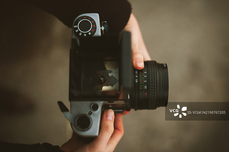 女人在户外手持复古胶卷相机，特写镜头图片素材