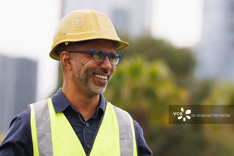 穿着高可视安全背心、硬帽和眼镜的工程师/建筑师肖像图片素材