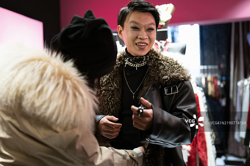 一位年轻时尚的亚洲男性在服装店里。图片素材