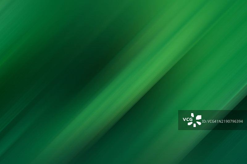 绿色运动模糊背景。清新的翡翠光波。绿色渐变流动的宁静。自然色调的抽象和谐。一场生机勃勃的绿色交响曲。图片素材