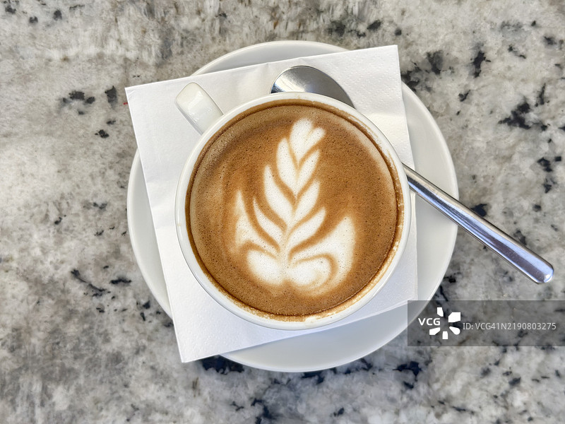 高角度视图的卡布奇诺，上面有叶子形状的拉花艺术图片素材