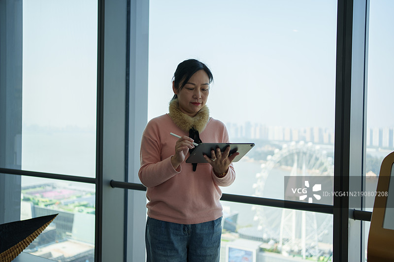 亚洲老年女性使用平板电脑图片素材