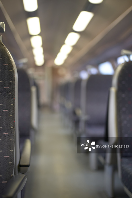 空荡荡的火车内部，座位排成行，前景突出。图片素材