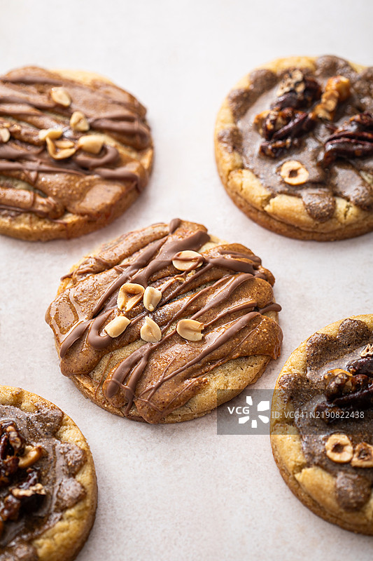 自制的焦糖巧克力饼干，配有榛子、花生酱、胡桃和巧克力。图片素材