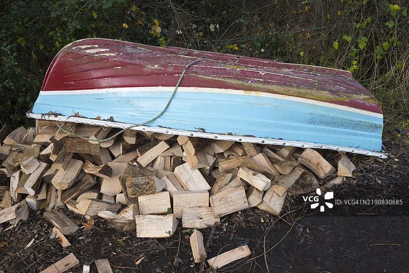 小船在肯宁顿的泰晤士河步道上遮挡着雨中的木柴图片素材