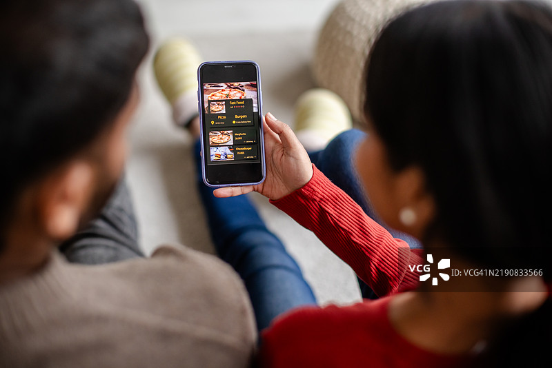 情侣在家一起浏览手机上的菜单图片素材